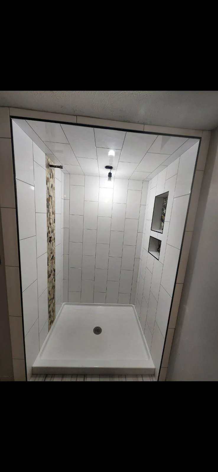 Walk-in shower installation with frameless glass enclosure